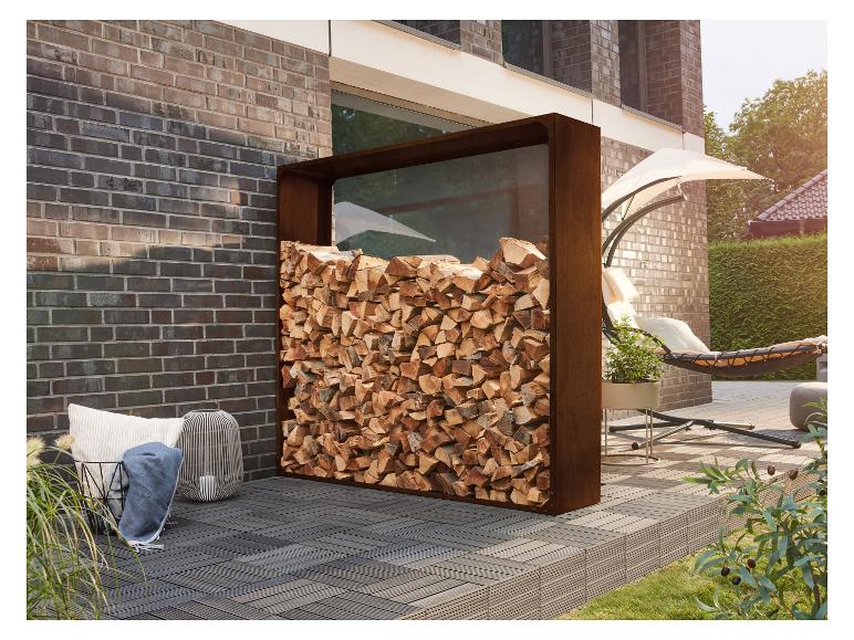 Buitenhaardhoutrek met gestapeld hout, naast een bakstenen muur en terrasmeubilair.