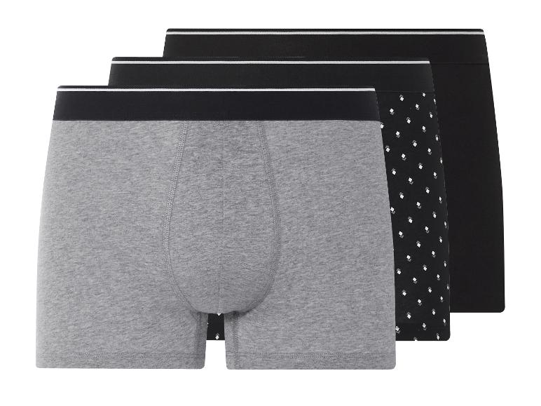 Drie heren boxershorts: grijs, effen zwart en zwart met stippen.