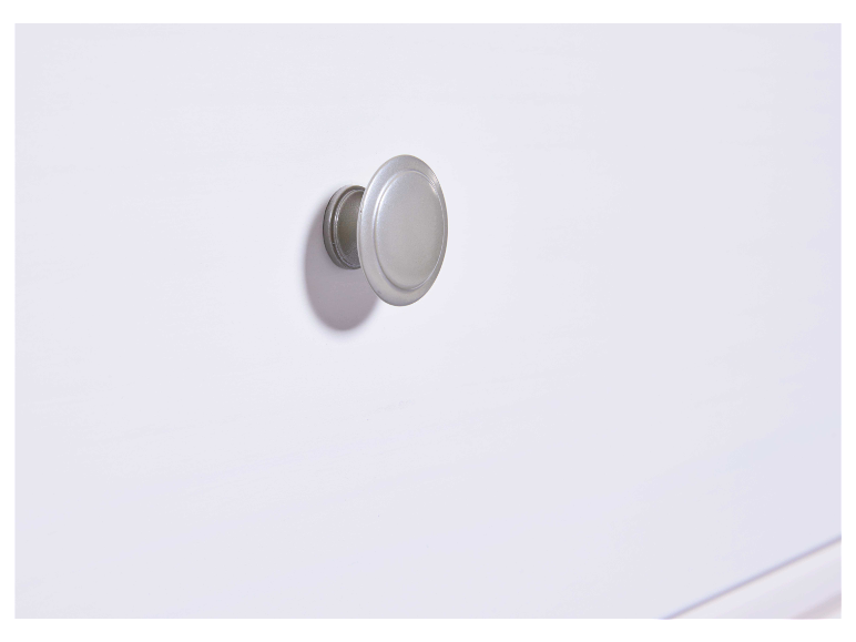 Zilveren ladeknop op een wit meubel.