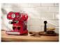 Rood retro espressomachine zet koffie op een houten aanrecht.