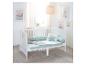 Wit babybedje met mintgroen beddengoed en decoratieve kussens in een lichte kamer.