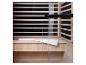 Infraroodsauna met houten interieur, glazen deur en een witte handdoek op de bank.