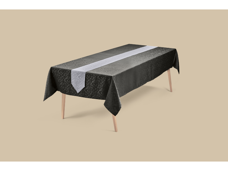 Zwart tafelkleed met patroon en een lichte tafelloper op een houten tafel.