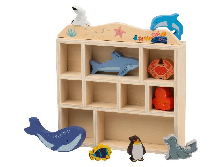 Houten plank met houten zeedieren, waaronder een walvis, een haai en een krab.