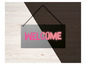 Een metalen bord met de tekst 'Welcome' in roze letters