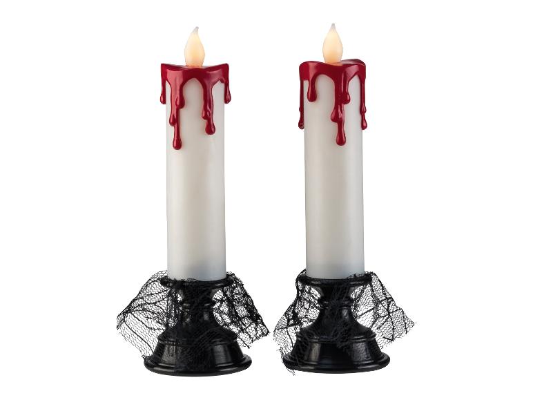 Twee Halloween-thema LED-kaarsen met rood druipend wax en zwarte kanten voetjes.