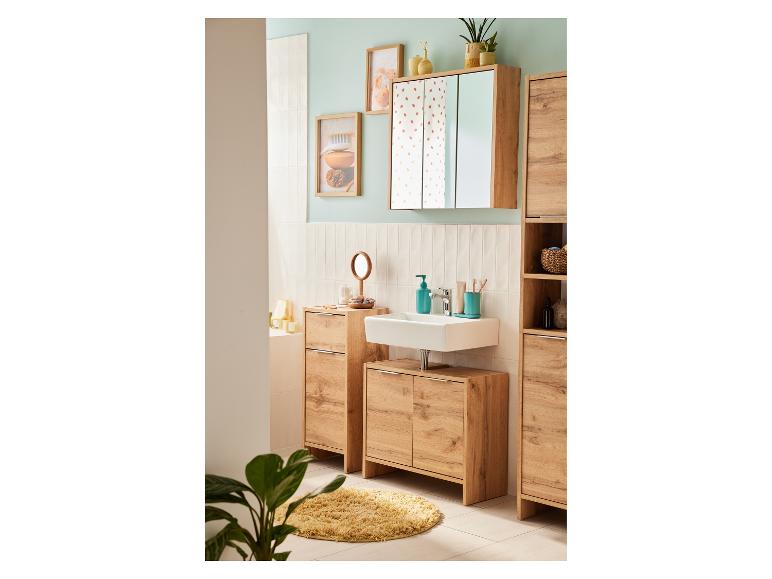 Lichte houten badkamermeubelen: wastafel, spiegelkast en opbergkolommen.