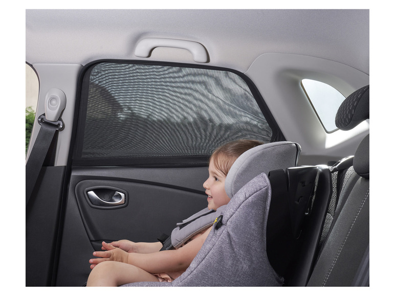 Een kind in een autostoeltje met een raamzonnescherm.