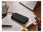 Tronic powerbank, smartphone en laptop op een bureau.