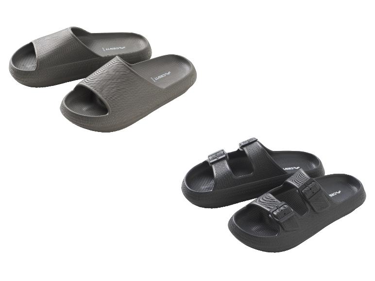 Twee paar comfortabele slippers: één grijs paar en één zwart paar met gespen.