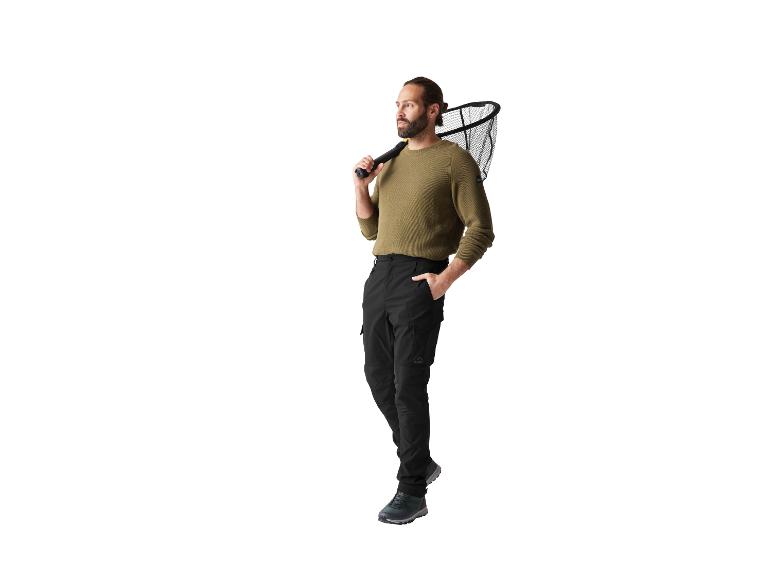 Man met Crivit sweater en broek, met een schepnet.