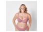 Een vrouw draagt ​​een roze bh en slip.