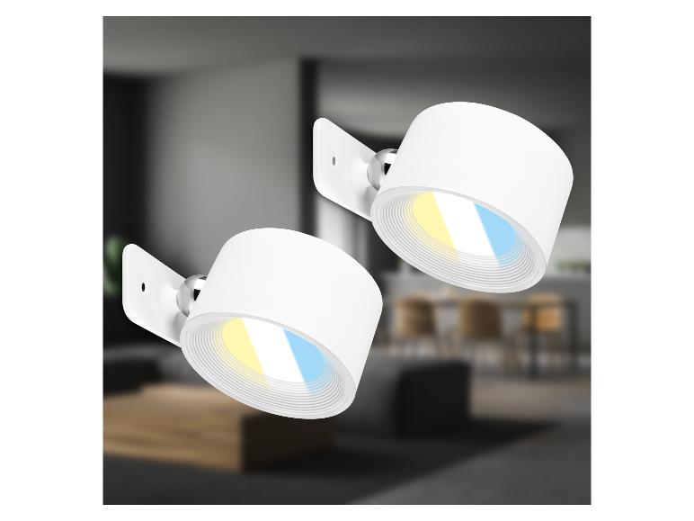 Twee witte verstelbare LED-spotlights met warme en koele lichtinstellingen in een moderne kamer.