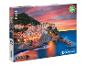 Doos voor een 1000-delige Clementoni puzzel met een afbeelding van een Italiaans dorp aan zee bij zonsondergang.