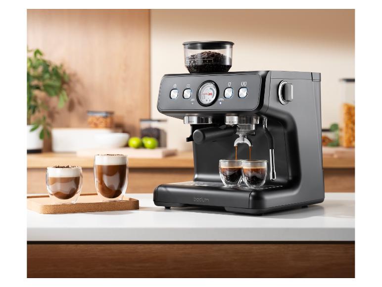 Een zwart Bodum espressomachine zet koffie in twee kleine glazen kopjes op een aanrecht.