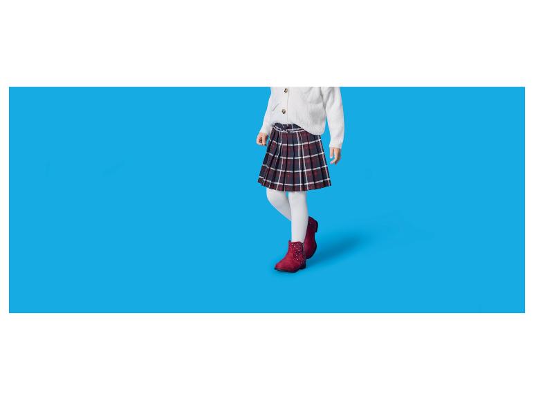 Kind in geruite rok, wit vest en rode laarzen