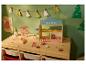 Kinderspeelcafé met houten speelgoedeten, menu en kerstversiering.