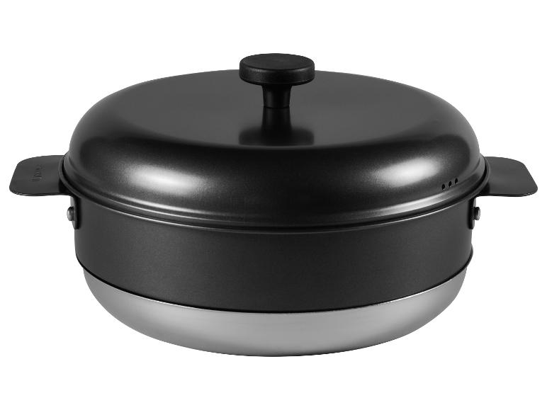 Zwarte stoompan met metalen onderkant en handvatten.