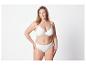 Een vrouw draagt een witte bh en slip.