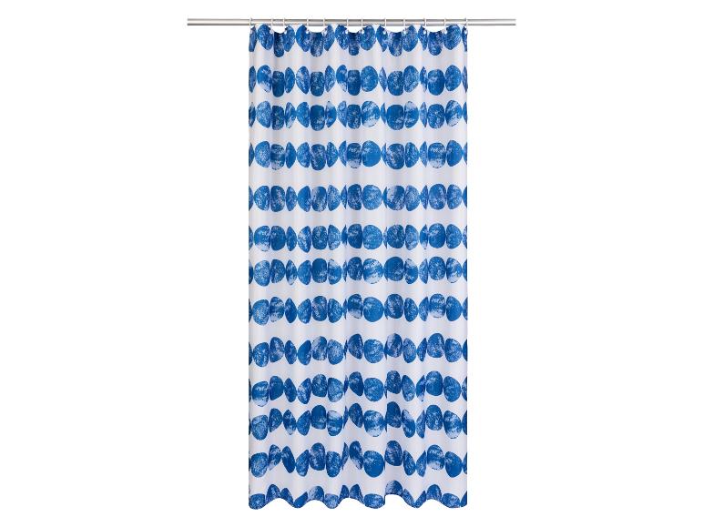 Een witte douchegordijn met blauwe, ronde patronen.