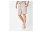 Lichtbeige herenshort en T-shirt met sneakers.