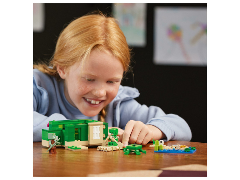 Een kind bouwt een LEGO Minecraft huis met een schildpad en een zwaard.