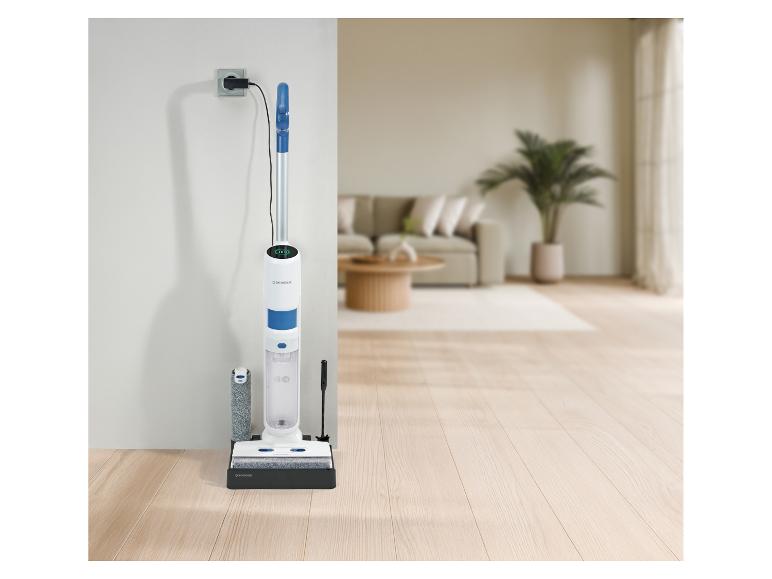 Witte en blauwe SilverCrest steelstofzuiger die wordt opgeladen via een stopcontact in een woonkamer.