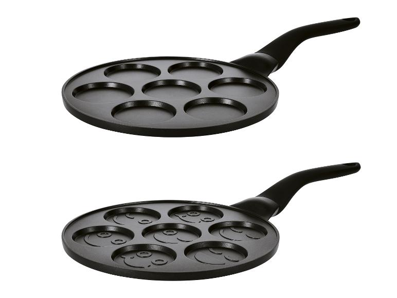Pannenkoekenpan met 7 inkepingen, één leeg, de andere met smileygezichten.