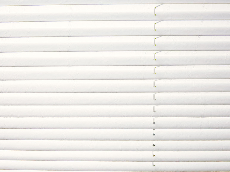 Witte jaloezieën met een textuur van gekreukt papier.