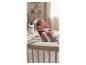 Baby in een grijze stoffen wipstoel in een kinderkamer met houten planken en decoratie.