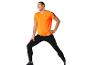 Man in sportkleding: oranje shirt en zwarte leggings.