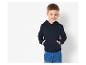 Een jongetje draagt een blauwe hoodie en jeans.