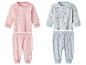 Twee sets babypyjama's: roze met sneeuwvlokken en blauw met manen en sterren.