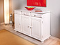 Witte houten dressoir met drie deuren en drie laden.