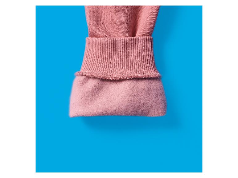 Close-up van een roze mouw met geribbelde manchet en zachte voering.