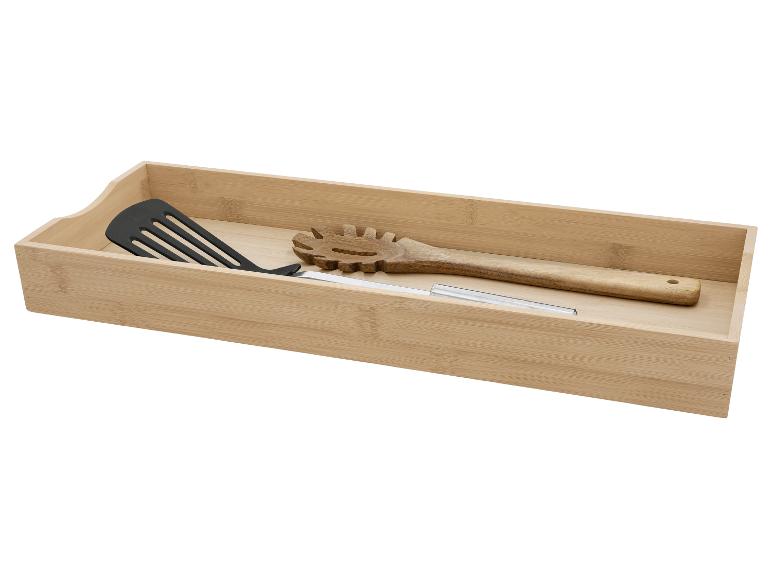 Bamboe lade-organizer met zwarte spatel, houten spaghettilepel en metalen keukengerei.