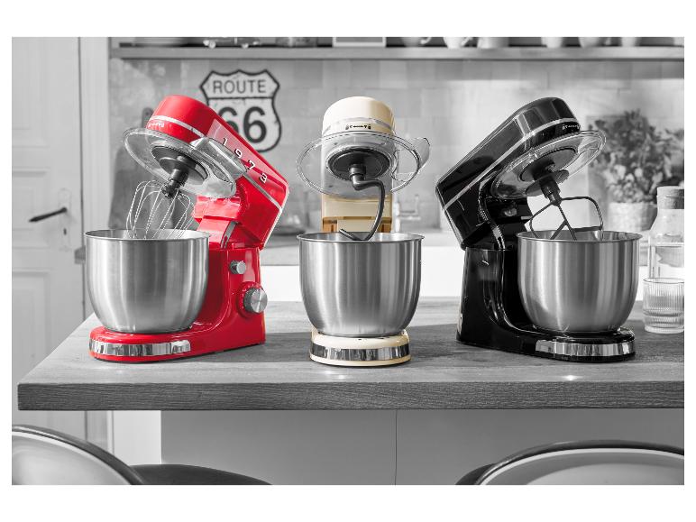 Drie vintage keukenmachines in rood, crème en zwart op een aanrecht.