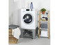Wasmachine met metalen onderstel en een bamboe plank met handdoeken en wasmand.