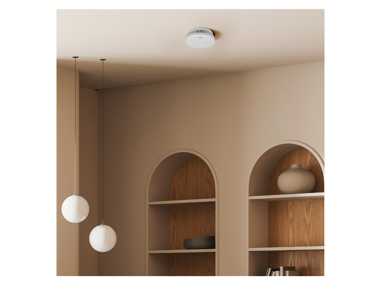 Rookmelder aan een licht plafond met decoratieve nissen en hanglampen.