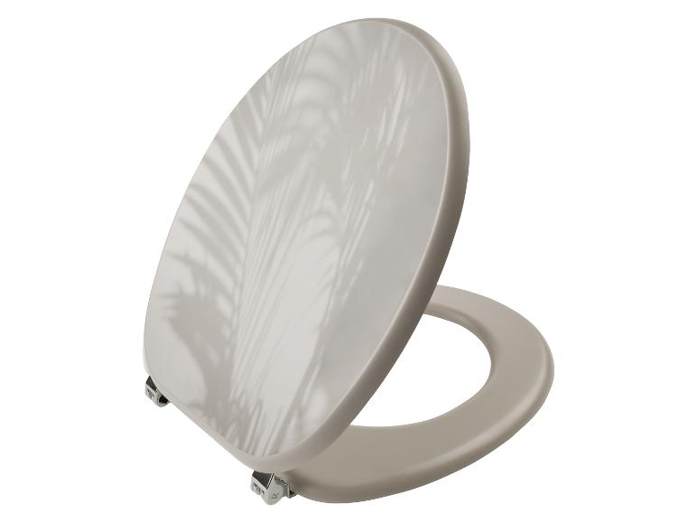 Een beige toiletbril met een tropisch bladontwerp.