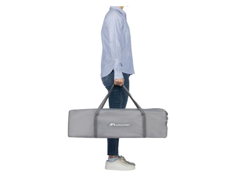 Iemand draagt een grijze Bébéconfort reiswieg.