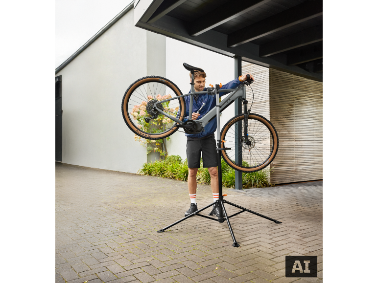 Man repareert een fiets op een fietsreparatiestandaard buiten.