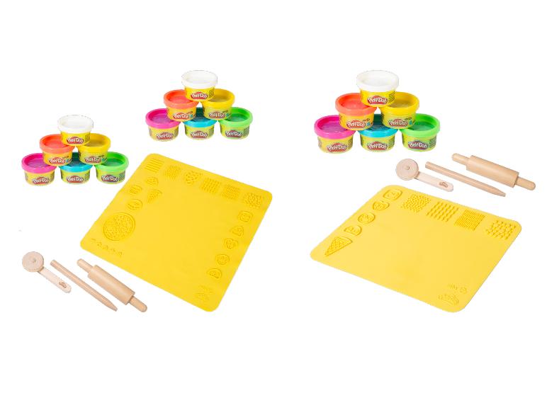 Klei set met gekleurde potjes, gele speelmatten en houten gereedschap.