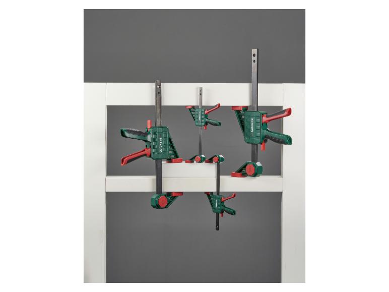 Stangklemmen in verschillende maten, bevestigd aan een wit frame.