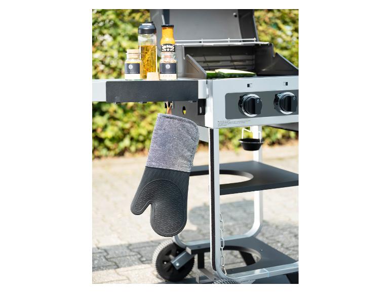 Ovenwant hangt aan een barbecue met kruiden en sauzen.