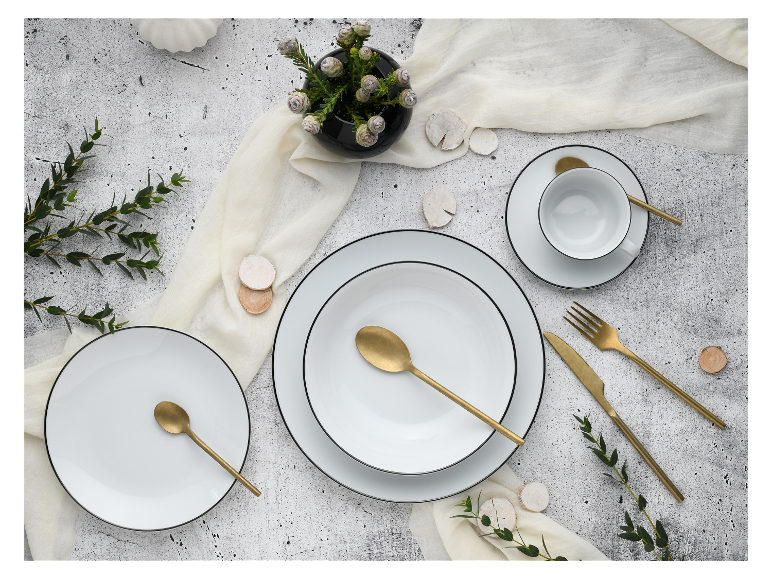 Wit en goud servies, gouden bestek, minimalistische stijl.