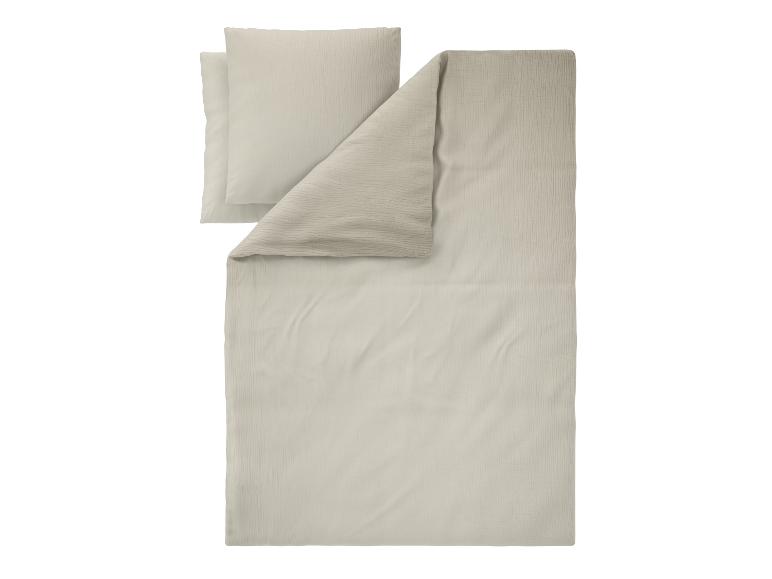 Beige mousseline katoenen beddengoed, bestaande uit een dekbedovertrek en twee kussenslopen.