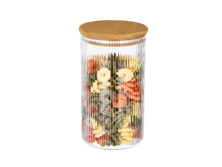 Glazen pot met houten deksel, gevuld met kleurrijke pasta.