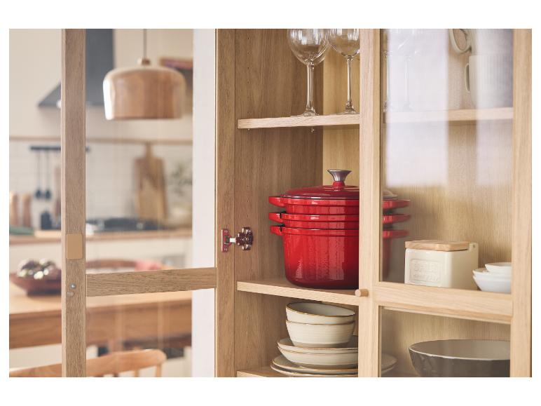 Rode gietijzeren potten en ander keukengerei in een houten kast.