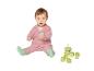 Baby in roze vestje en groene sokken speelt met bouwblokken en stapelspeelgoed.